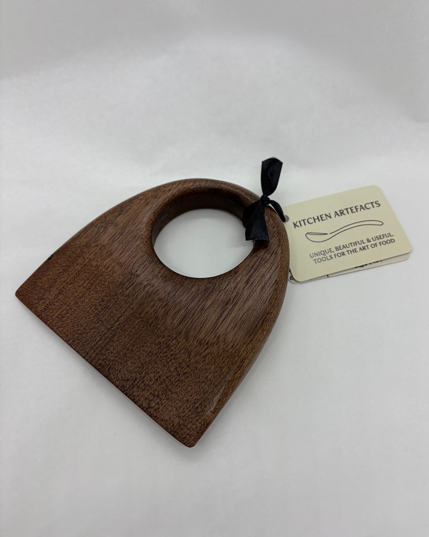 Wooden food chopper with a 'Kitchen Artefacts' tag